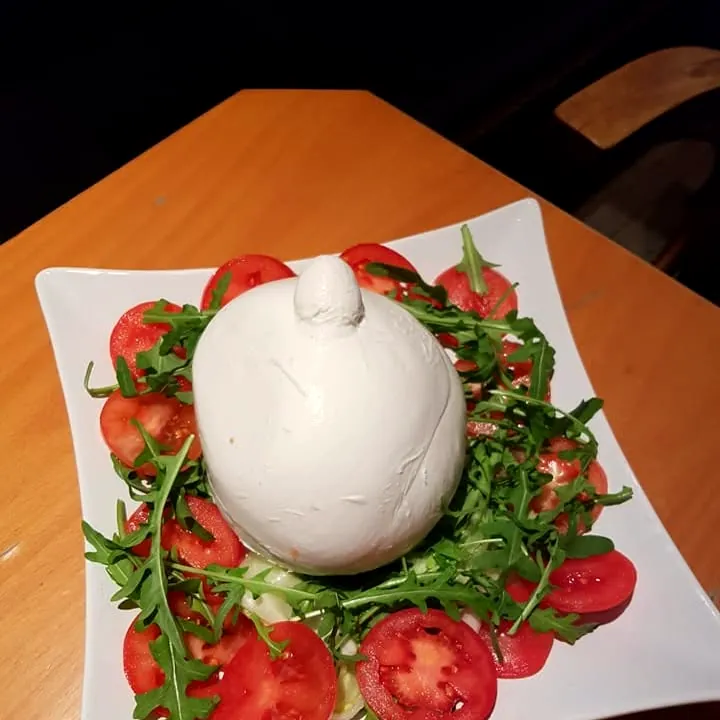 Burrata auf Tomatenscheiben und Rucola