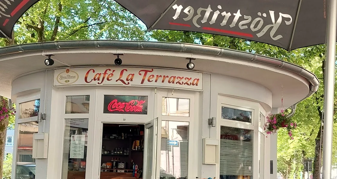 Das Dach unseres Pavillons mit dem roten Schriftzug Café La Terrazza unter Sonnenschirm und Bäumen